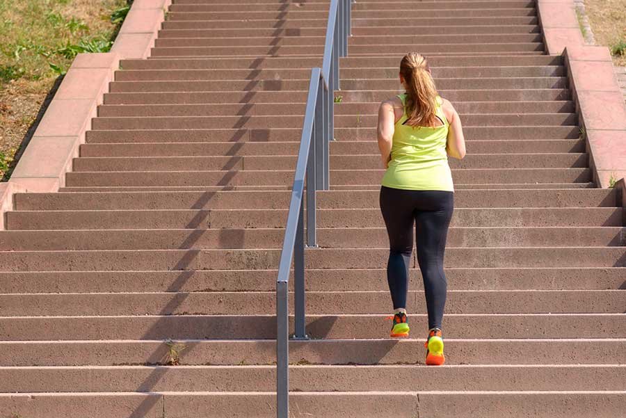 Mulher adulta subindo uma escadaria