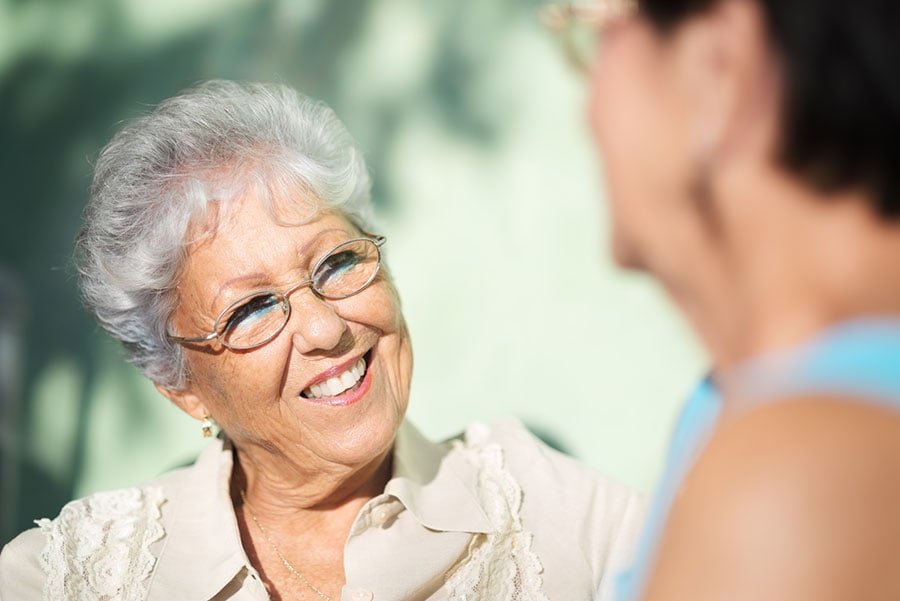 Senhora sorrindo conversa com alguém